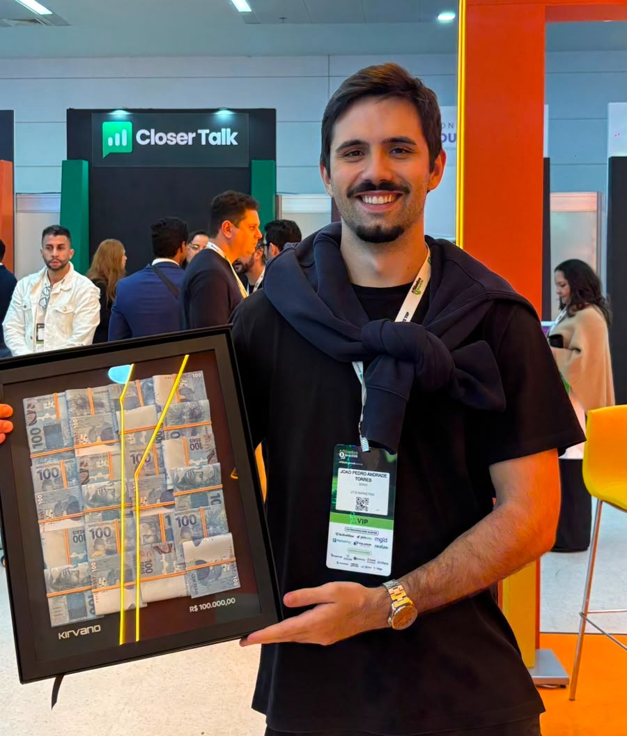 João Pedro Torres segurando a placa da Kirvano de R$100 mil faturados.